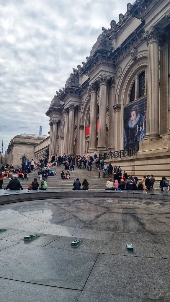 The MET filled with people sitting on the steps.