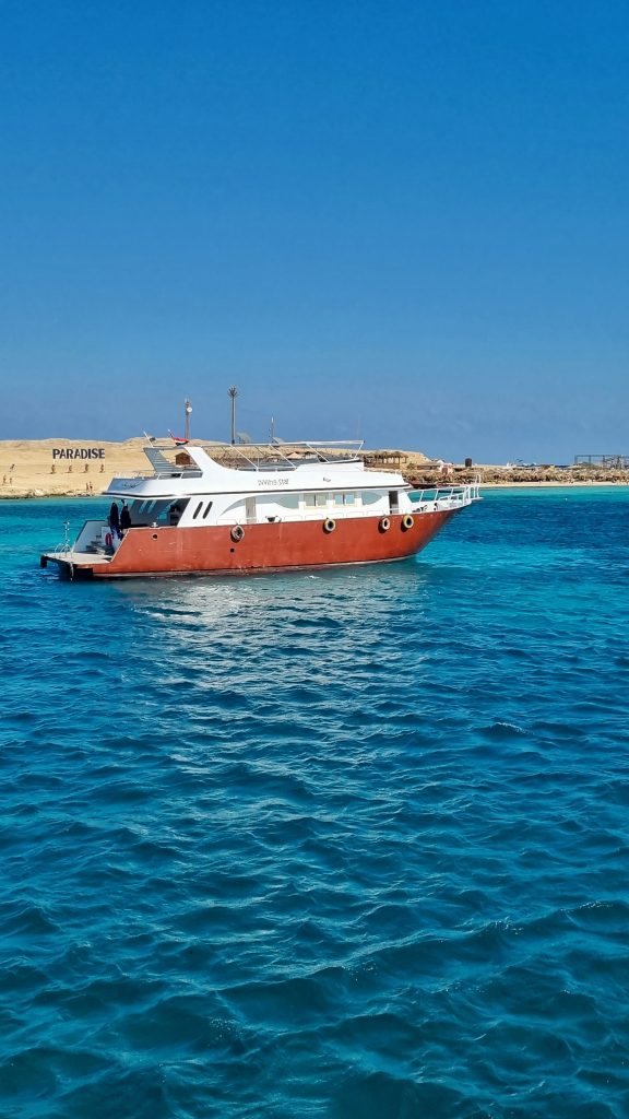 Red and white boat ion the Red Sea where you can see Paradise Island and the large Paradise sign in the background.