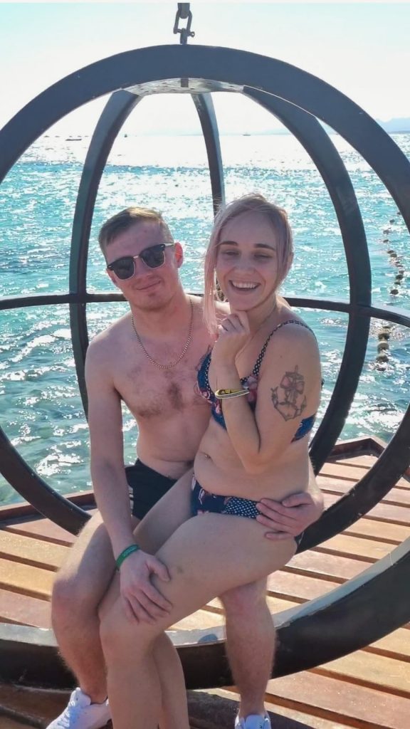 Amy was sitting on Liam's lap on one of the props on Paradise island. Behind them you can see the sun shining on the beautiful blue Red Sea.