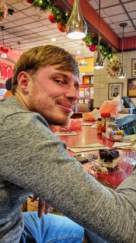 Liam enjoying some of his Orea Cheesecake at Juniors. You can also see some beautiful Christmas ornaments in the background.