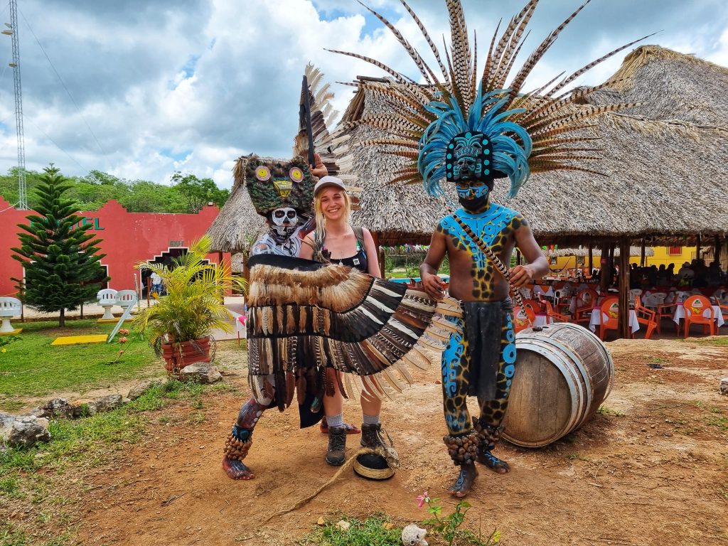 Amy with two people dressed up in Mayan wear at Chichen Itza.