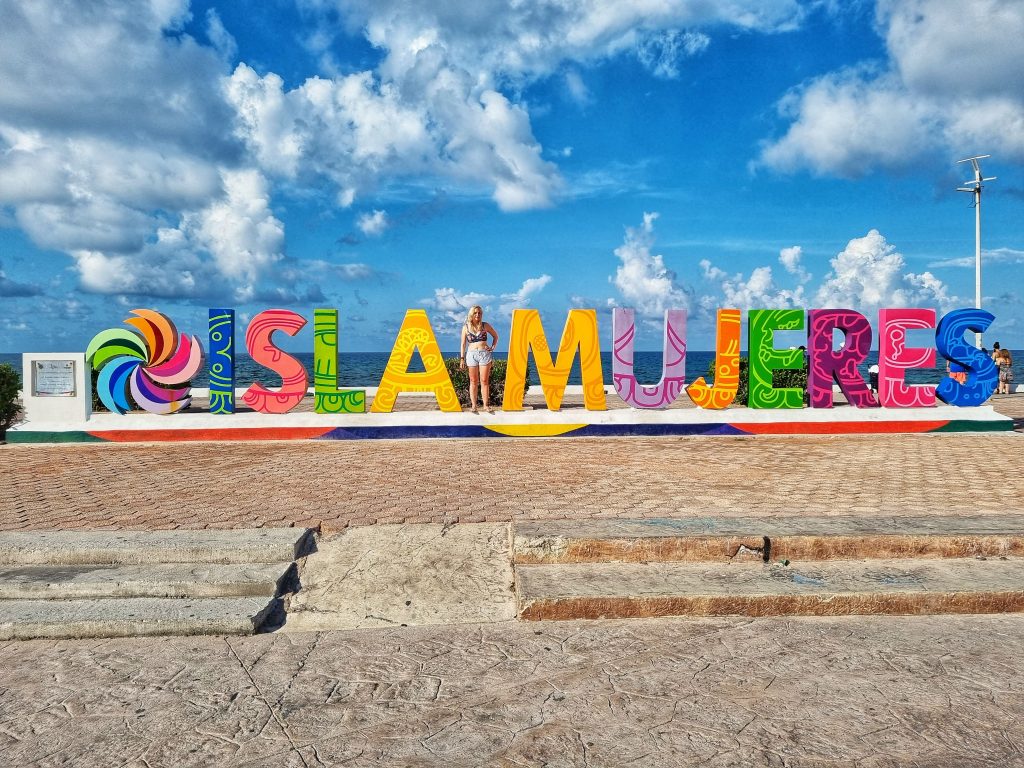 Isla Mujeres sign with Amy standing in the middle.