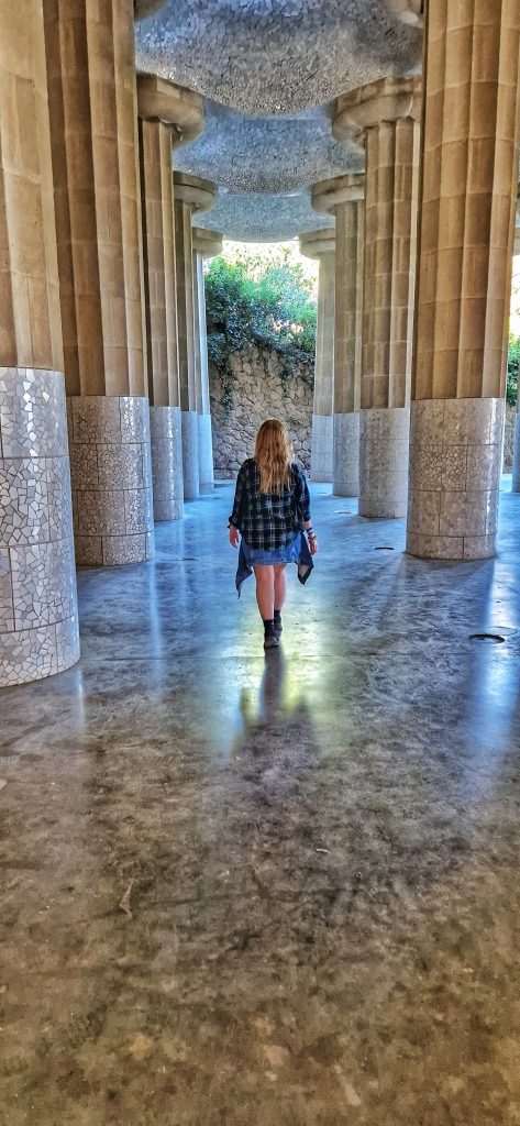 Amy walking through some of the columns in Parc Guell.