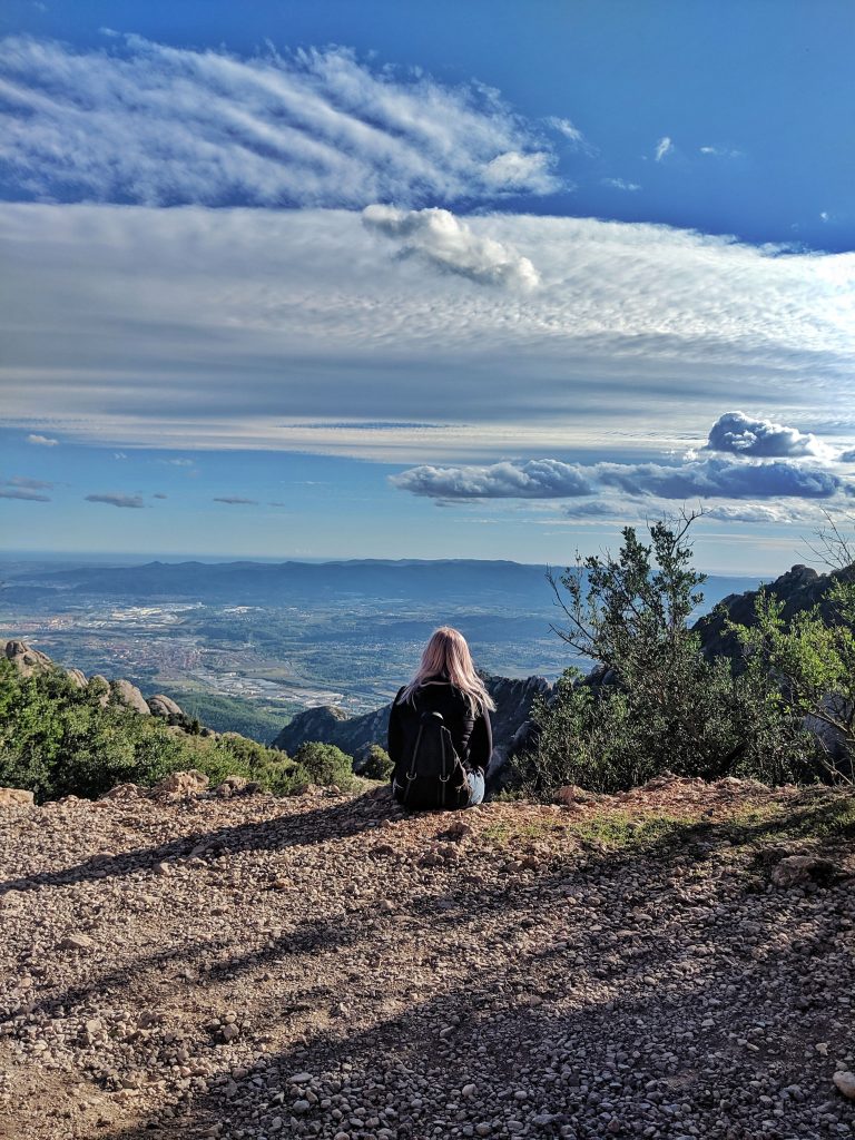 Amy sitting on the edge of one of the hills on Montserrat overlooking the view of Catalonia.