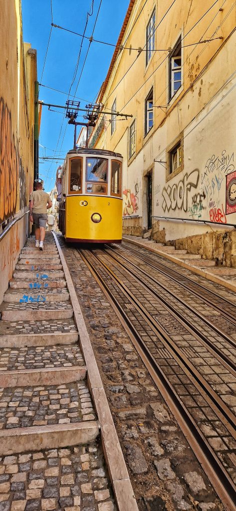 Liam walking up one of the hills in Lisbon with the yellow tram coming down in the other direction.