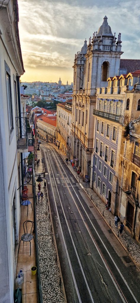 One of the streets in Lisbon with the sun setting in the distance.