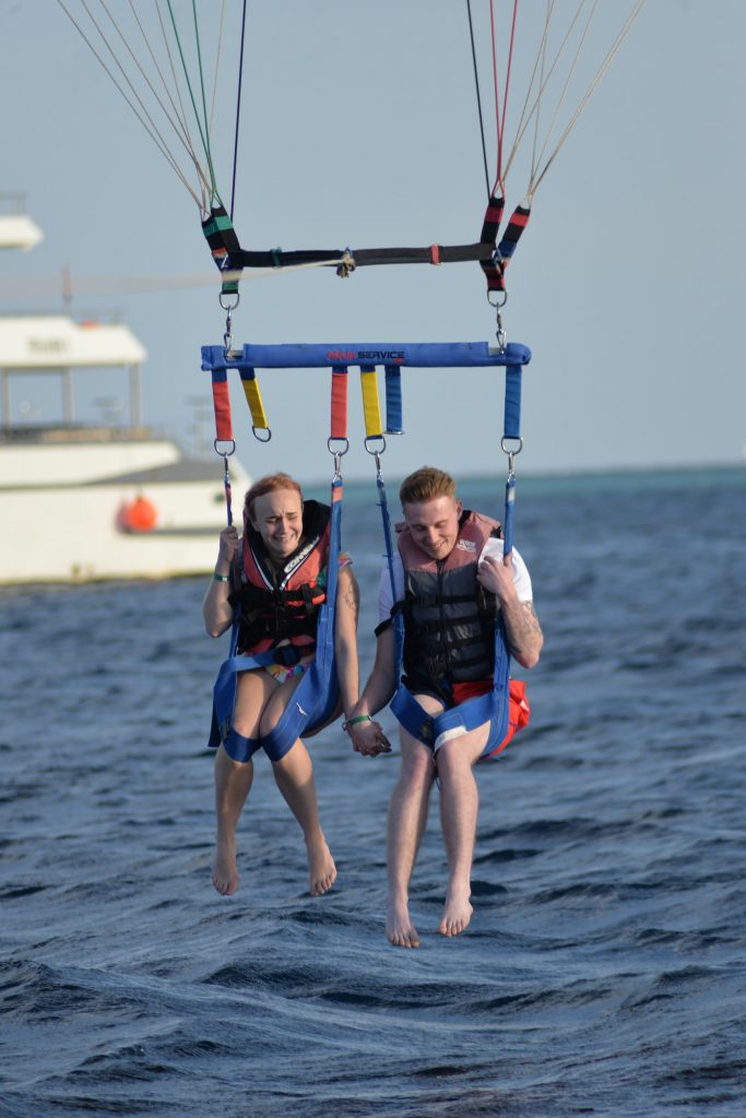 Amy & Liam holding hands whilst they're parasailing and about to enter the Red Sea.