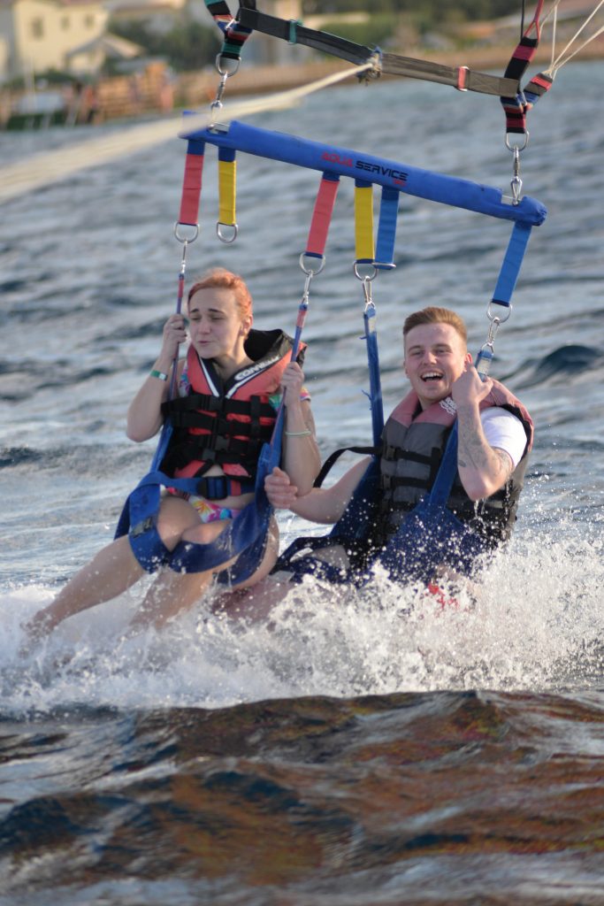 Liam and Amy entering the Red Sea during their parasailing experience. Amy's face is a picture as she tries to brace the cold sea!