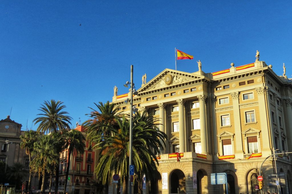One of the buildings in Plaza de Colon with plenty of Spanish flags decorated around it.