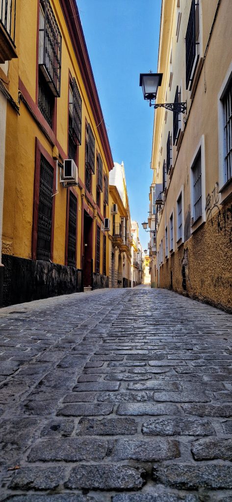 Cobblestoned Streets in Seville with the beautiful bright yellow buildings.