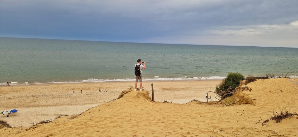 When we went on the Donana National Park tour we were also taken to a beautiful beach. This image shows Liam standing on the edge of a sand slope taking some photos and videos of the beautiful beach.