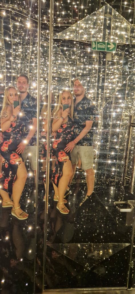 Amy & Liam on the Virgin Voyages ship by the Manor nightclub.