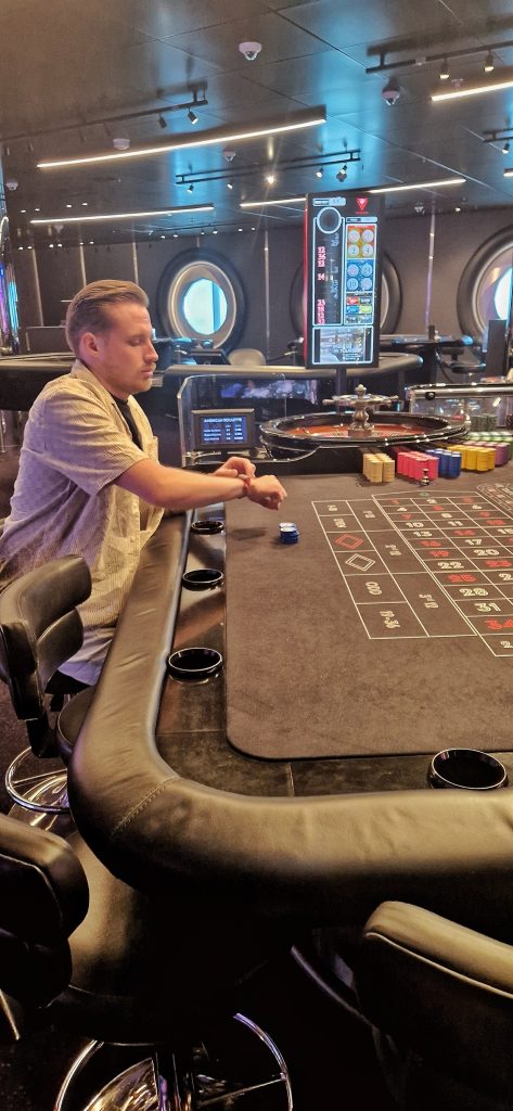 Liam sitting in the casino playing roulette.