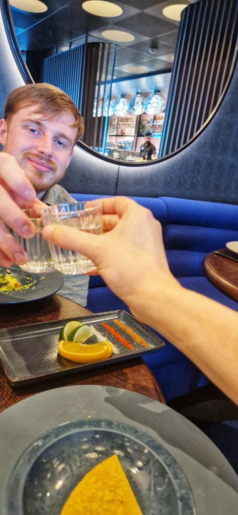 Amy & Liam toasting to the delicious Mezcal at Virgin Voyages Pink Agave Mexican restaurant.