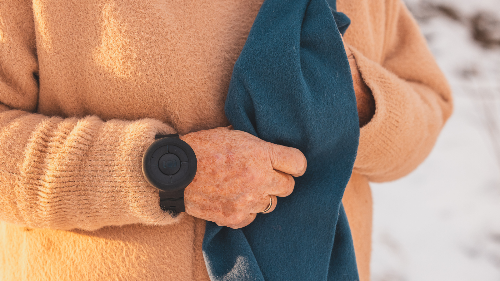 An arm with a mobile social alarm (Posifon Nano) on it.