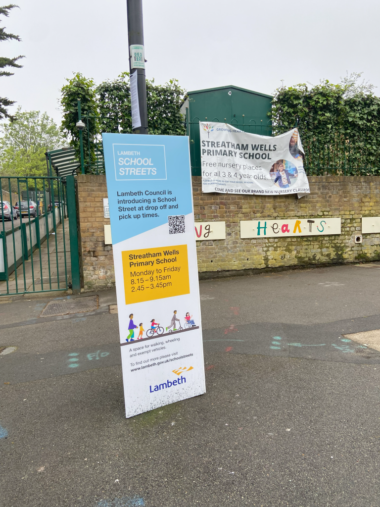 Photograph of an information board tied to a lamp post outside the school