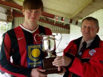 Presteigne St Andrews FC Max Powell receives the Otway Cup from sponsor Mick Mills