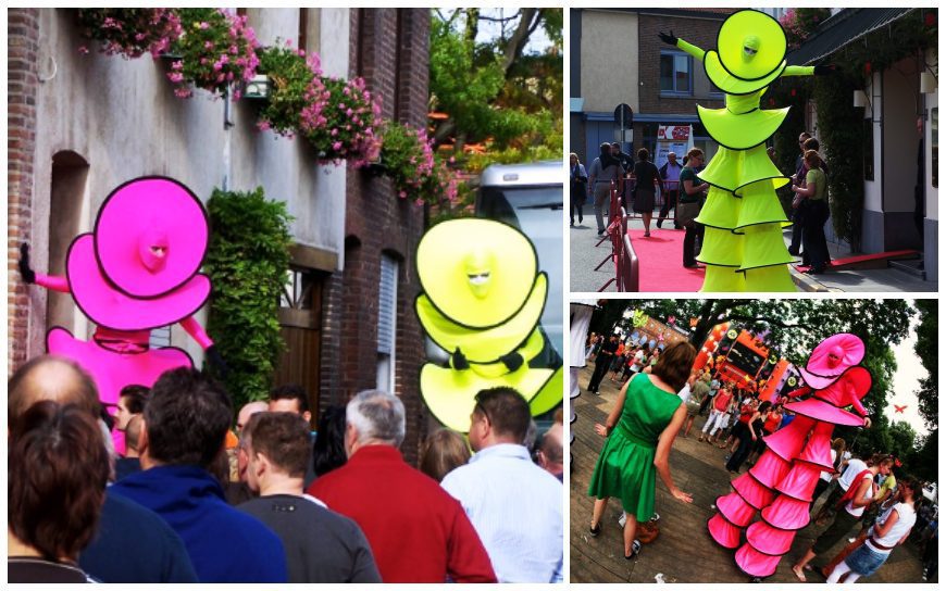 Cirque Colour Steltenlopers: Elegante figuren in roze en geel voor betoverend entertainment op uw event! Flexibele speeltijd en LED-optie beschikbaar.