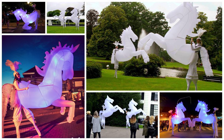 Magische White Horses Steltenlopers: Betoverende nachtdans. Ervaar de poëtische parade en magie van verlichte stelten in de duisternis.