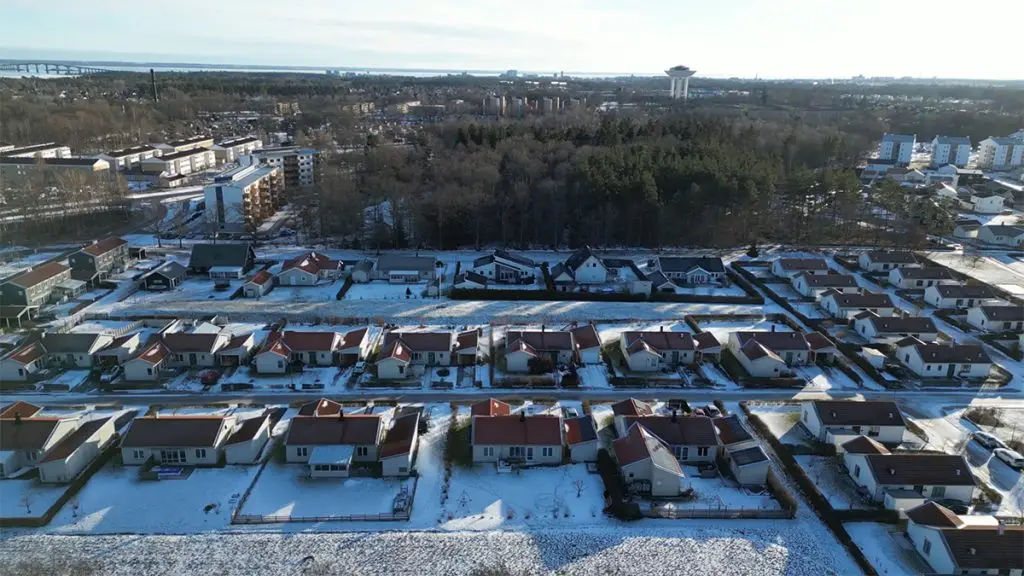 Ett flygfoto av ett bostadsområde med snö på marken.