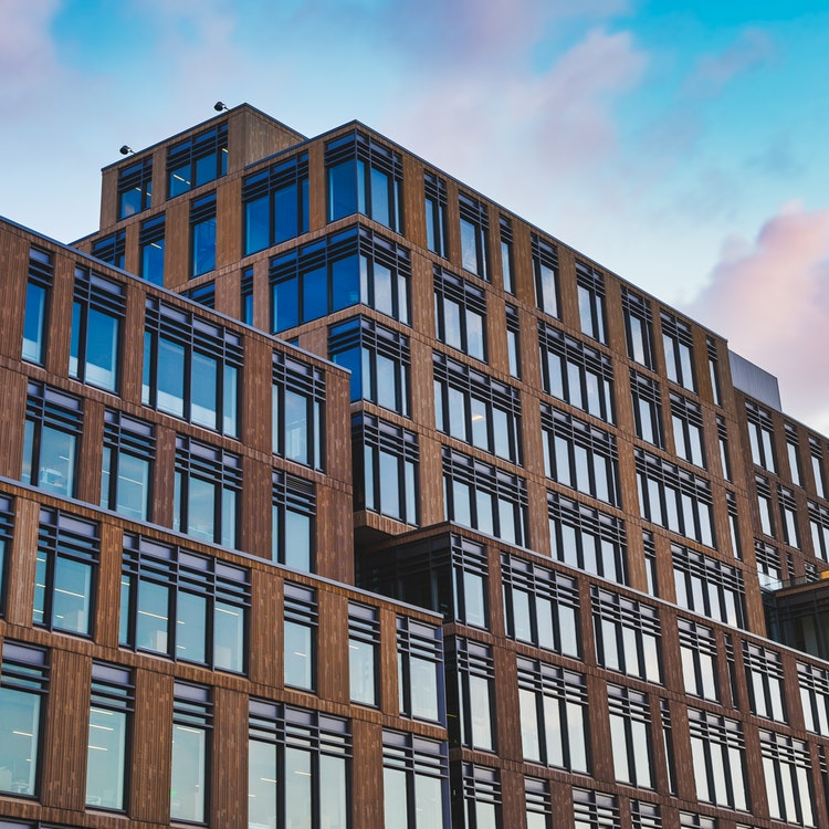 large office block with blue sky and pink clouds