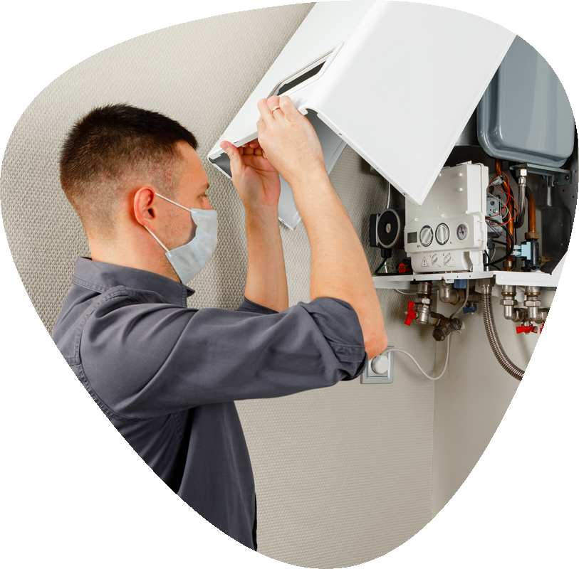 engineer wearing a mask opening a gas boiler to service