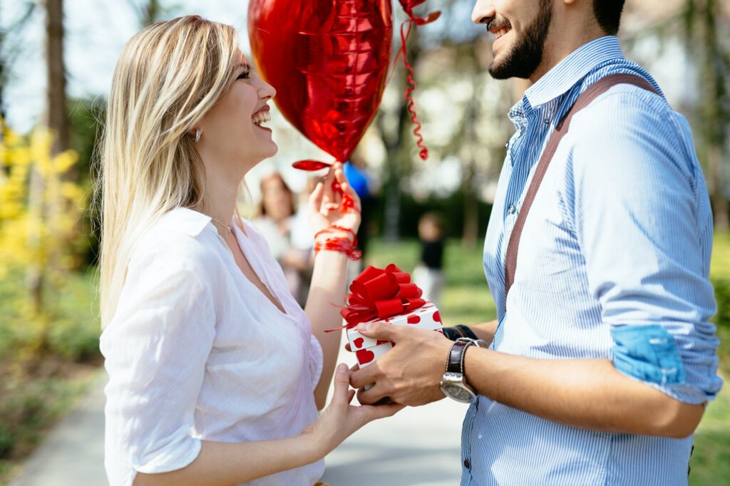 Man giving surprise gift as present to his lovely girlfriend