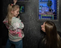 Une petite fille et sa maman en pleine activité lors d’une sortie en famille à Bruxelles avec enfants, explorant un jeu interactif à Prison Island.