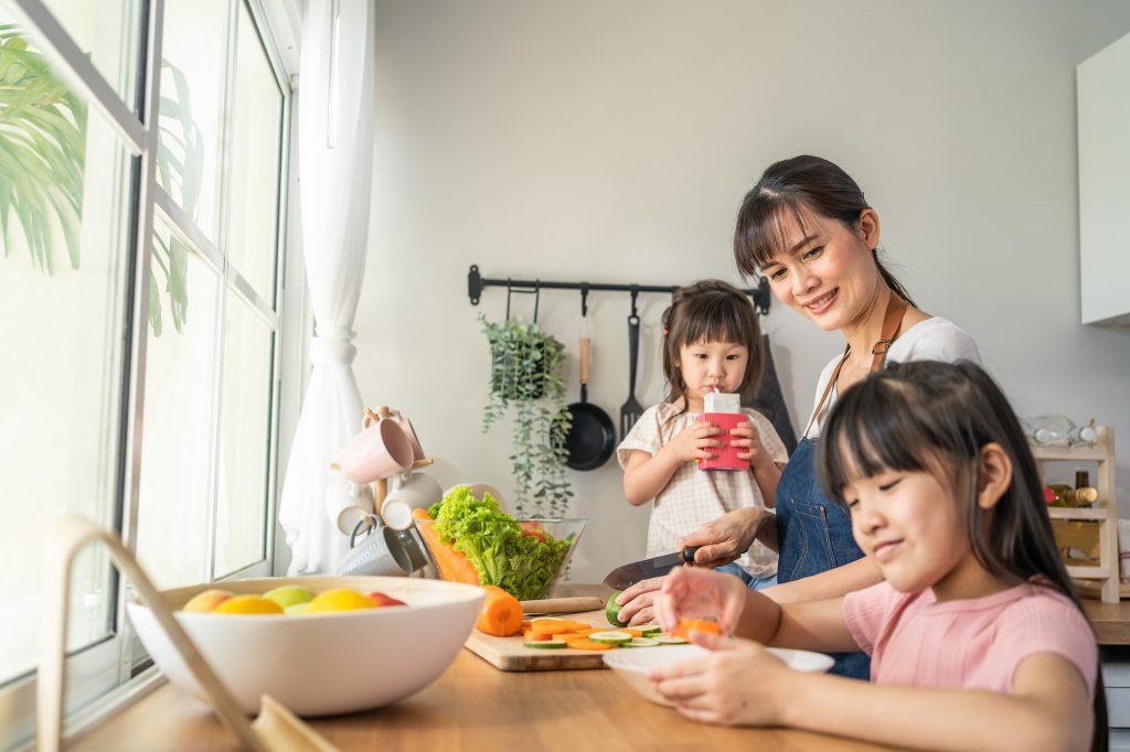 Asian happy family, mom and little sibling cute girl child cook foods in kitchen
