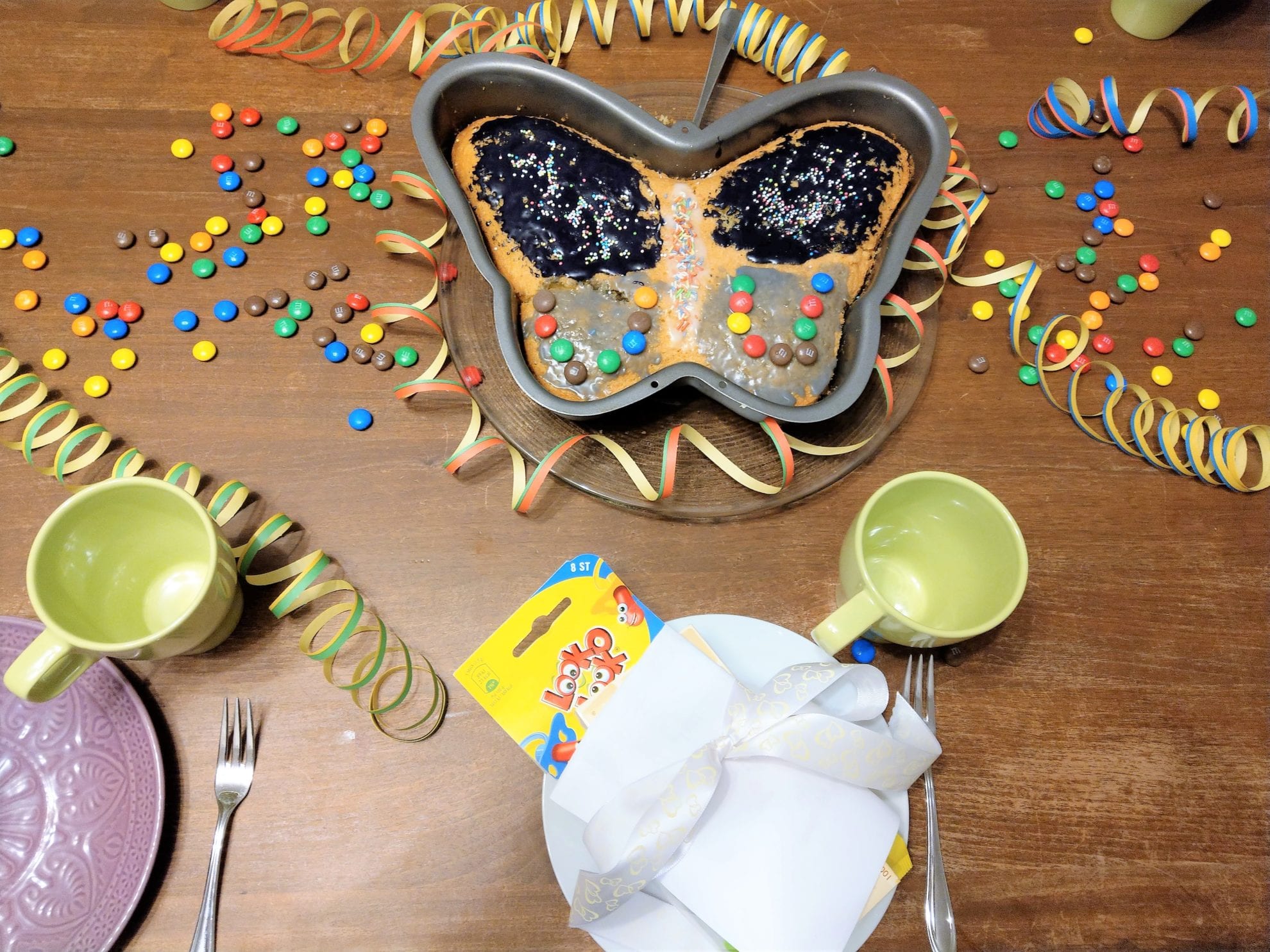 Der Geburtstagstisch ist gedeckt mit einem Schmetterlingskuchen für den großen Tag der Großen