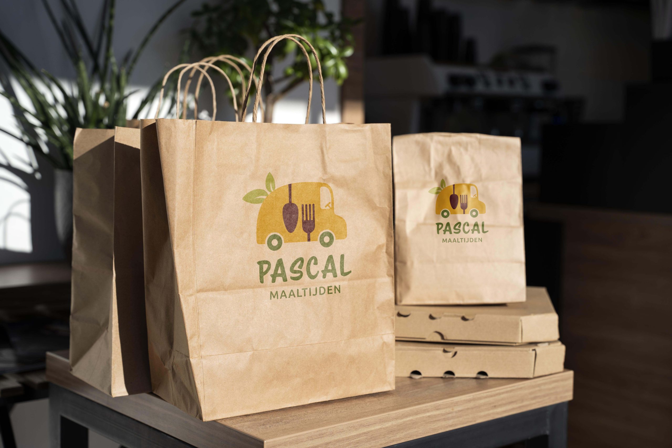Bruine papieren zakken met het logo van Maaltijden Pascal.