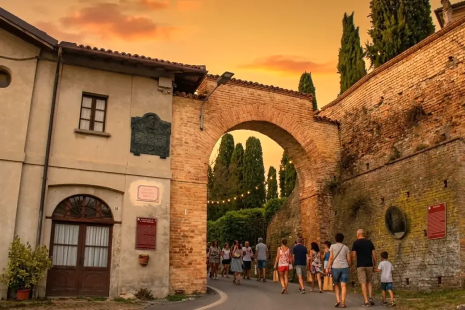 L'affascinante ingresso del borgo di Oliva Gessi si accende dei colori del tramonto e di file di luminarie, pronto per la festa.