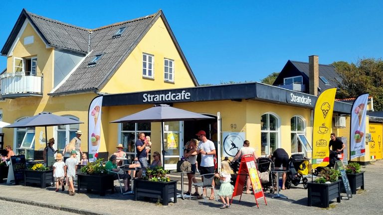 Rågeleje Strandcafés gule facade og udendørs servering