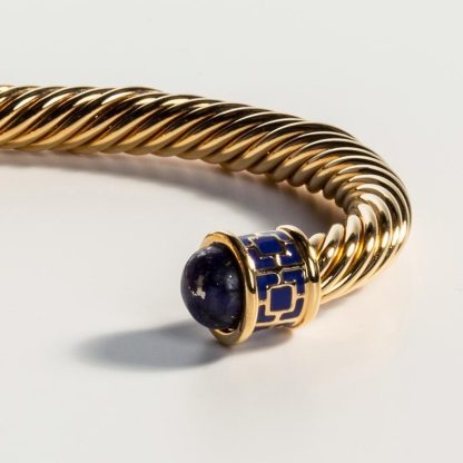 Maya Torque Deep Cobalt & Gold Bangle This bangle is made from brass, plated with 18 carat gold and twisted into a curved freeform silhouette with each end adorned with an deep cobalt enamel finish