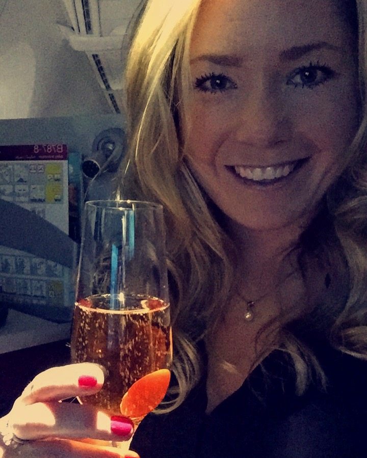 a picture of me having wine in business class after I got an upgrade