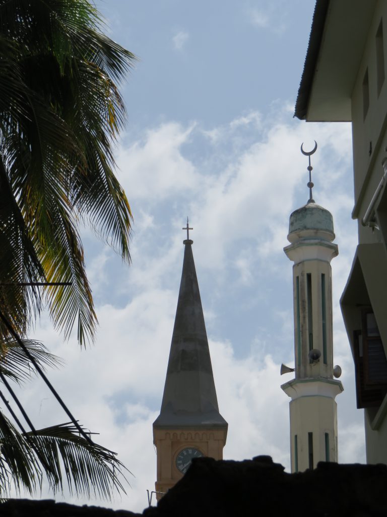 tower of a church and a mosque side by side