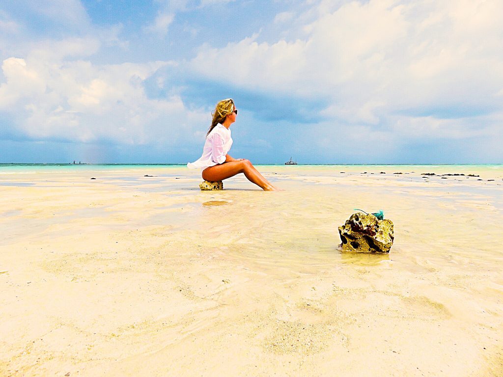 A picture of me sitting on a rock on a beach