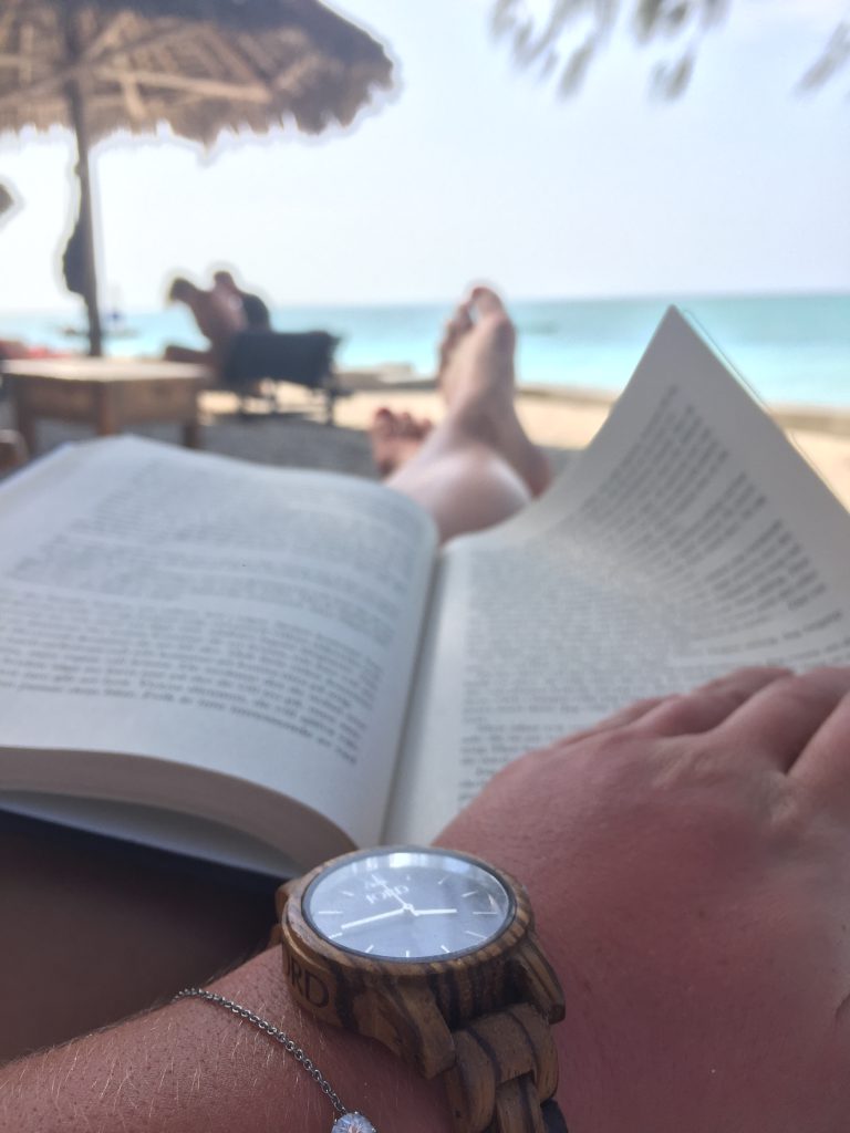 a picture of me on a beach reading a book recovering from jet lag