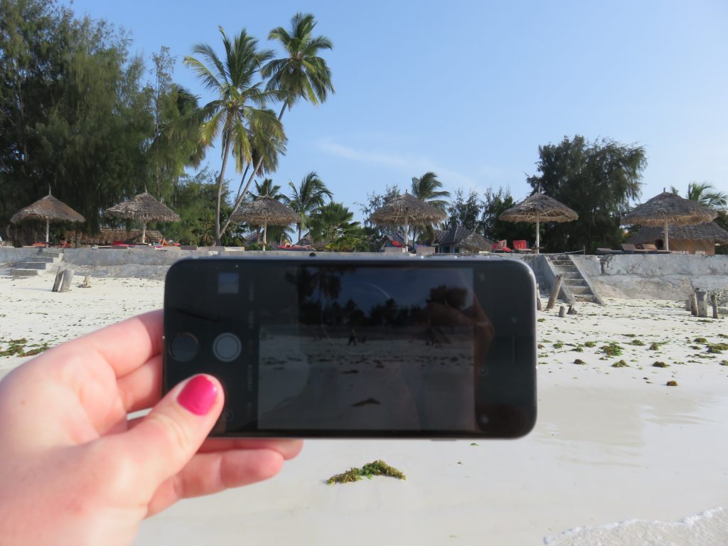 Me taking a photo of a beach with my iPhone