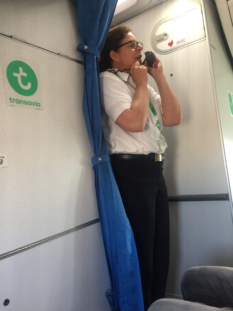 a picture of the crew member making an announcement on the flight
