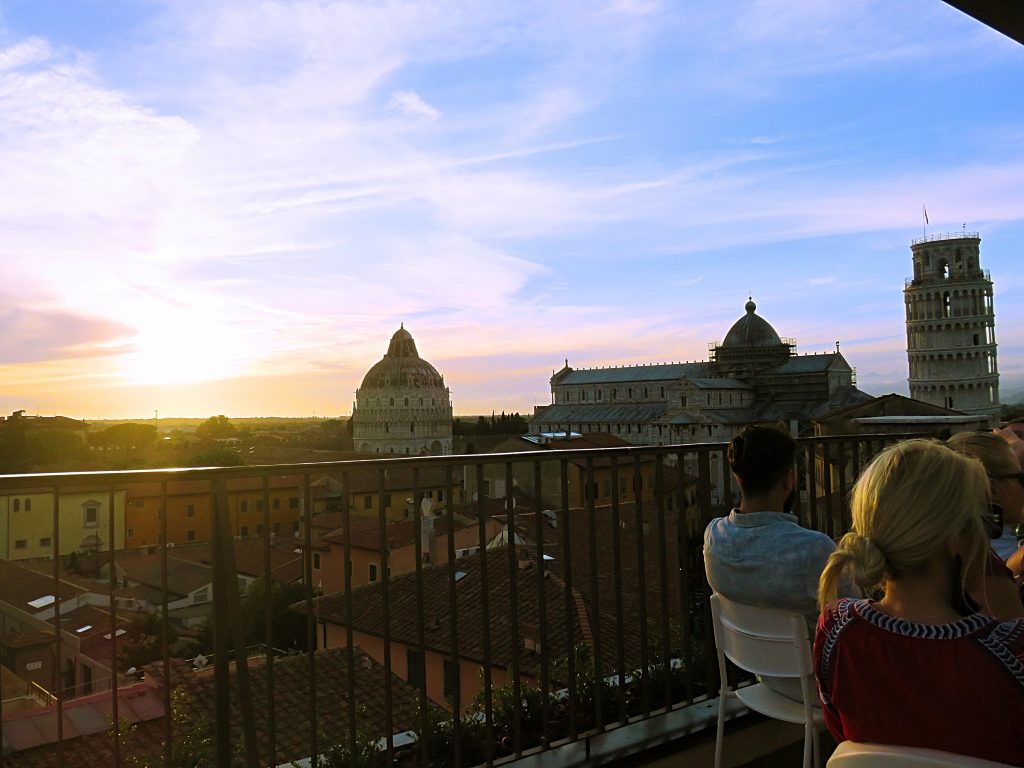 a picture of tourists at sunset enjoying the view from the rooftop restaurant 