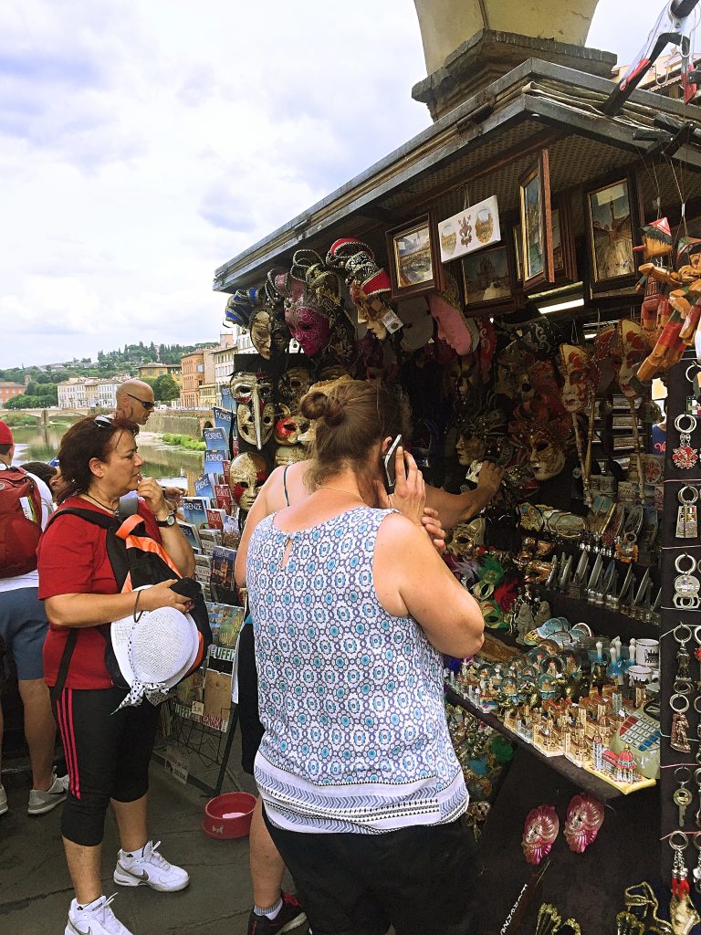 A picture of a tourist talking on the phone at a souvenir shop