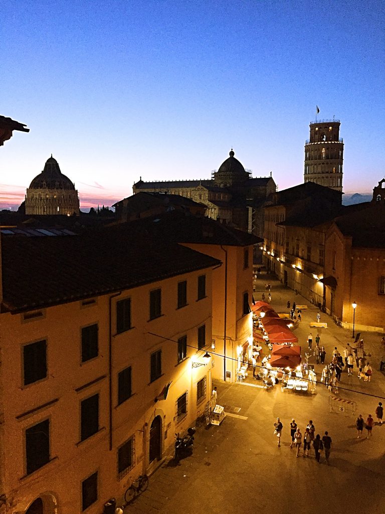 a view of the street and the leaning tower of pisa from the hotel