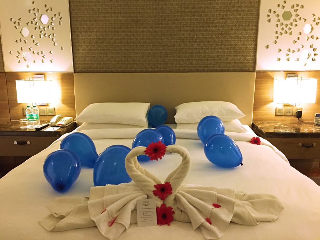 A picture of balloons and towel filed in the shape of swans by housekeeping