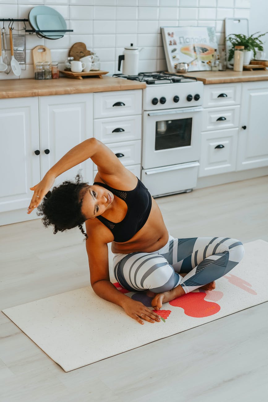 pretty woman doing yoga at a kitchen floor