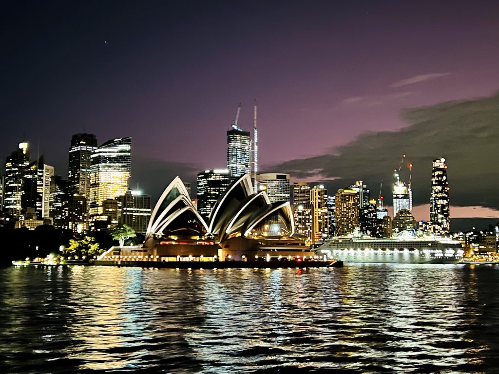Sydney skyline and Opera House seen from the water at night  is why Sydney is the ultimate travel destination 
