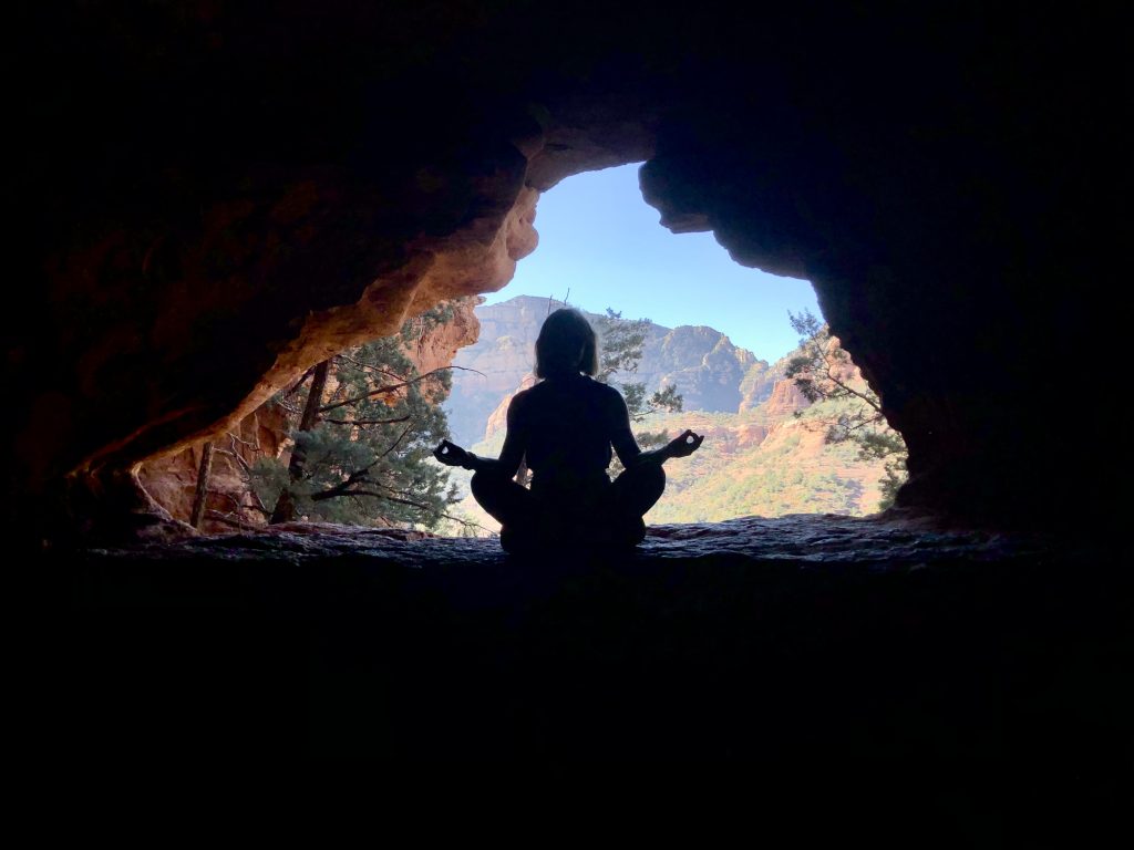 Woman meditating in a cave for stress management