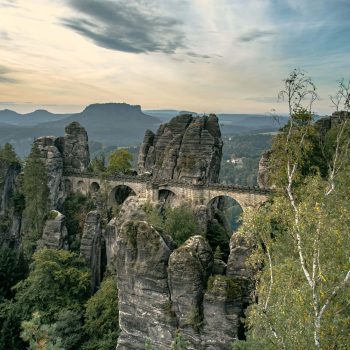 Blick auf die Basteibrücke in der Sächsischen Schweiz mit dem Lilienstein im Hintergrund.