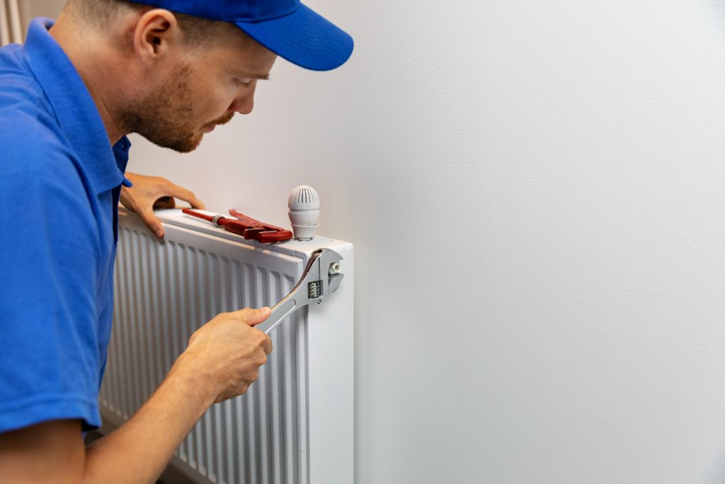 house heating system installation plumber installing radiator