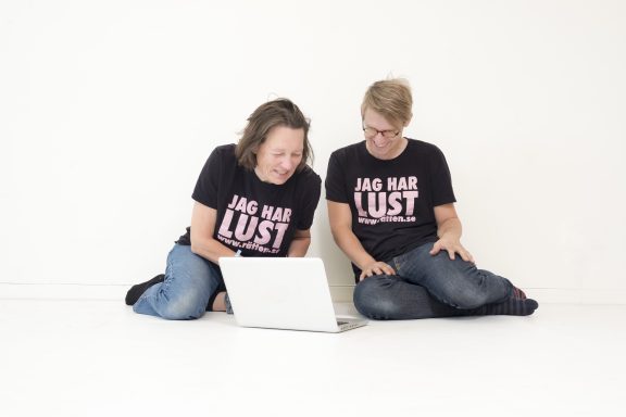 Två personer sitter och tittar i en dator.